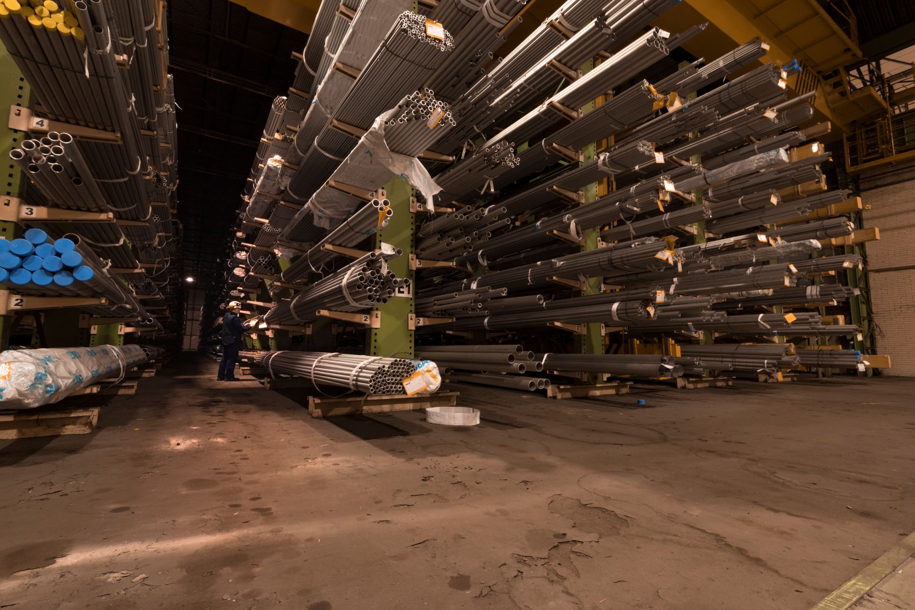 Steel pipes organised on warehouse storage racks, illustrative photography